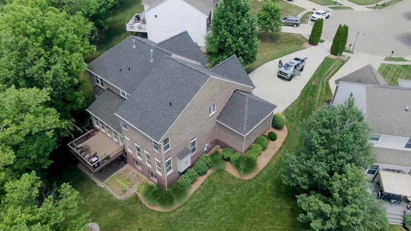 Aerial view of gray shingle roof on two-story brick home