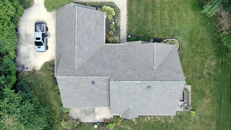 Top-down view of gray shingle roof with truck in driveway